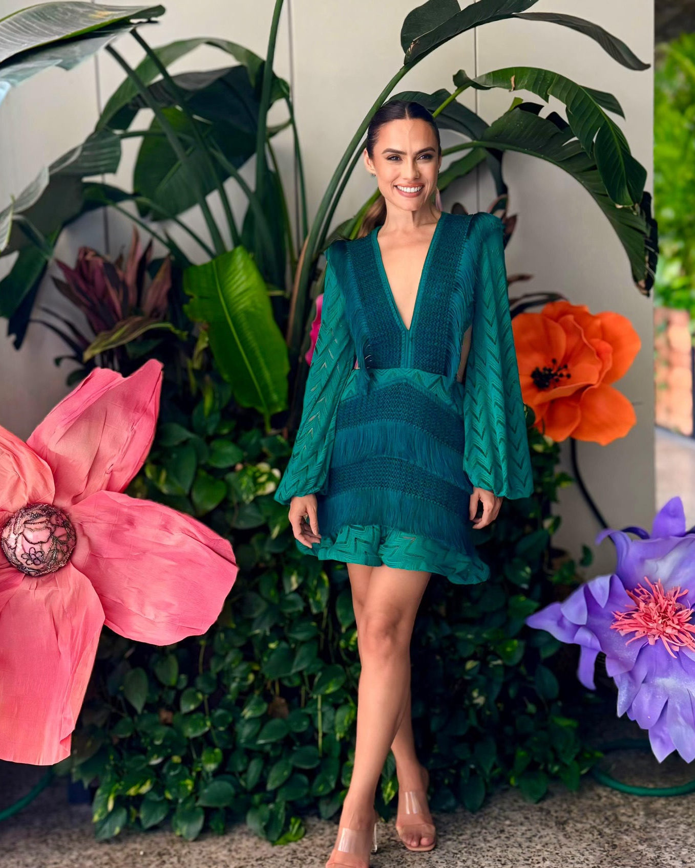 A guest in an emerald PatBO mini among the giant paper flowers