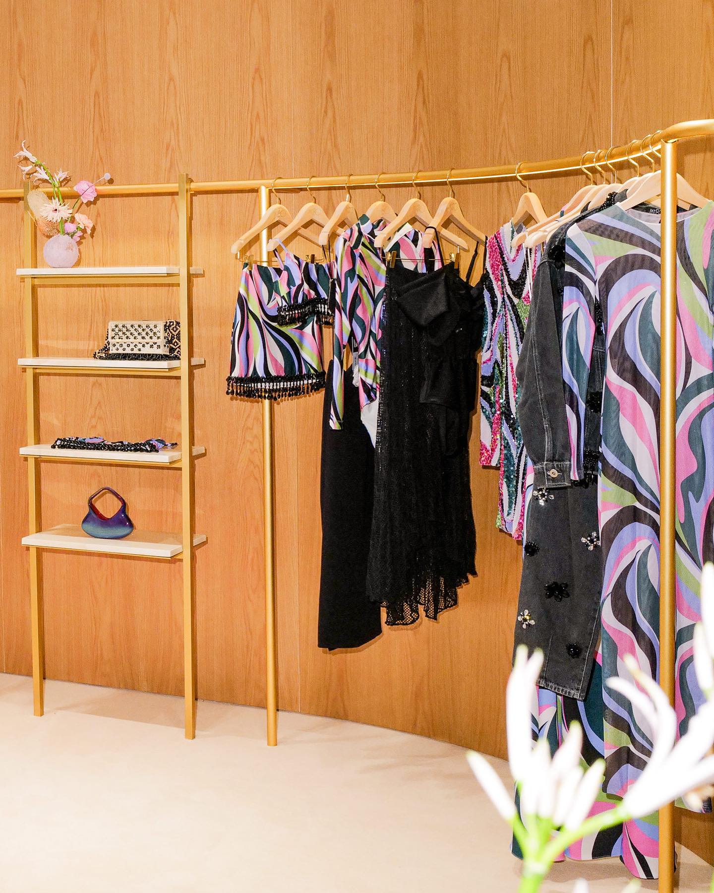 The collection on brass rails against warm wood walls