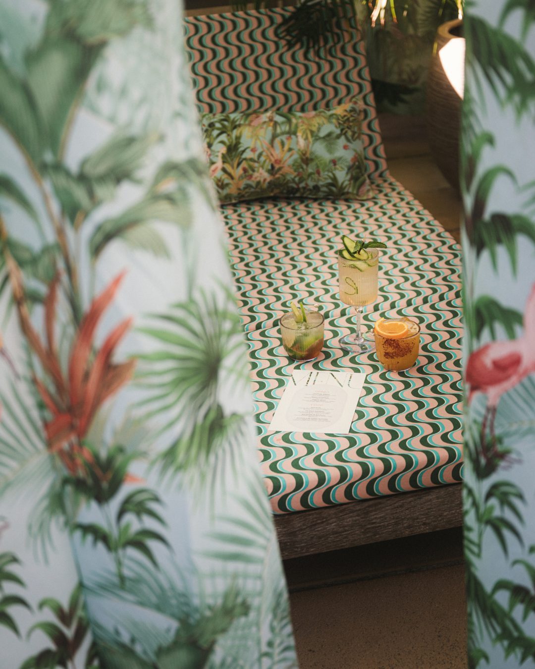 Daybed with cocktails seen through the cabana curtains