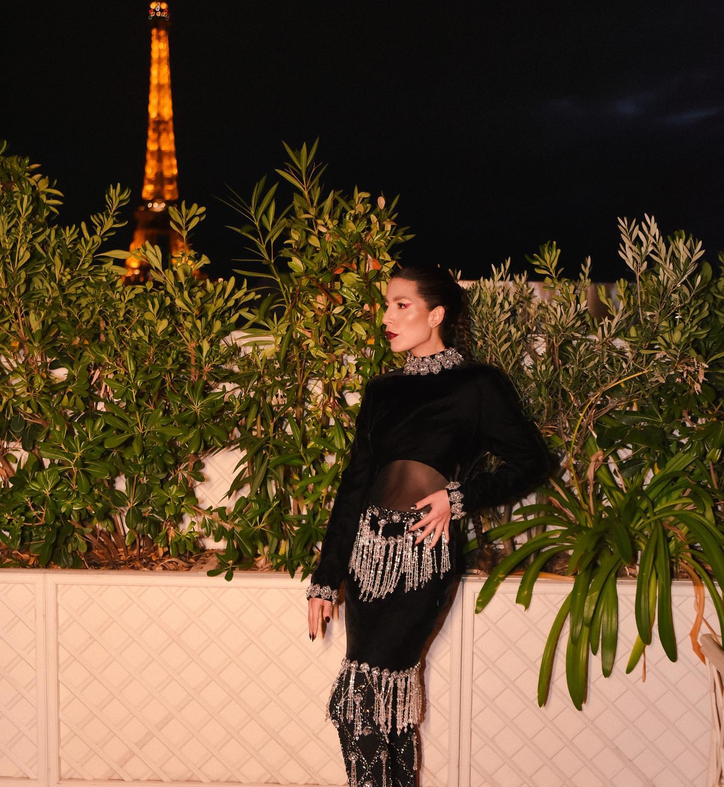 A guest in black velvet PatBO with crystal fringe, Eiffel Tower lit behind