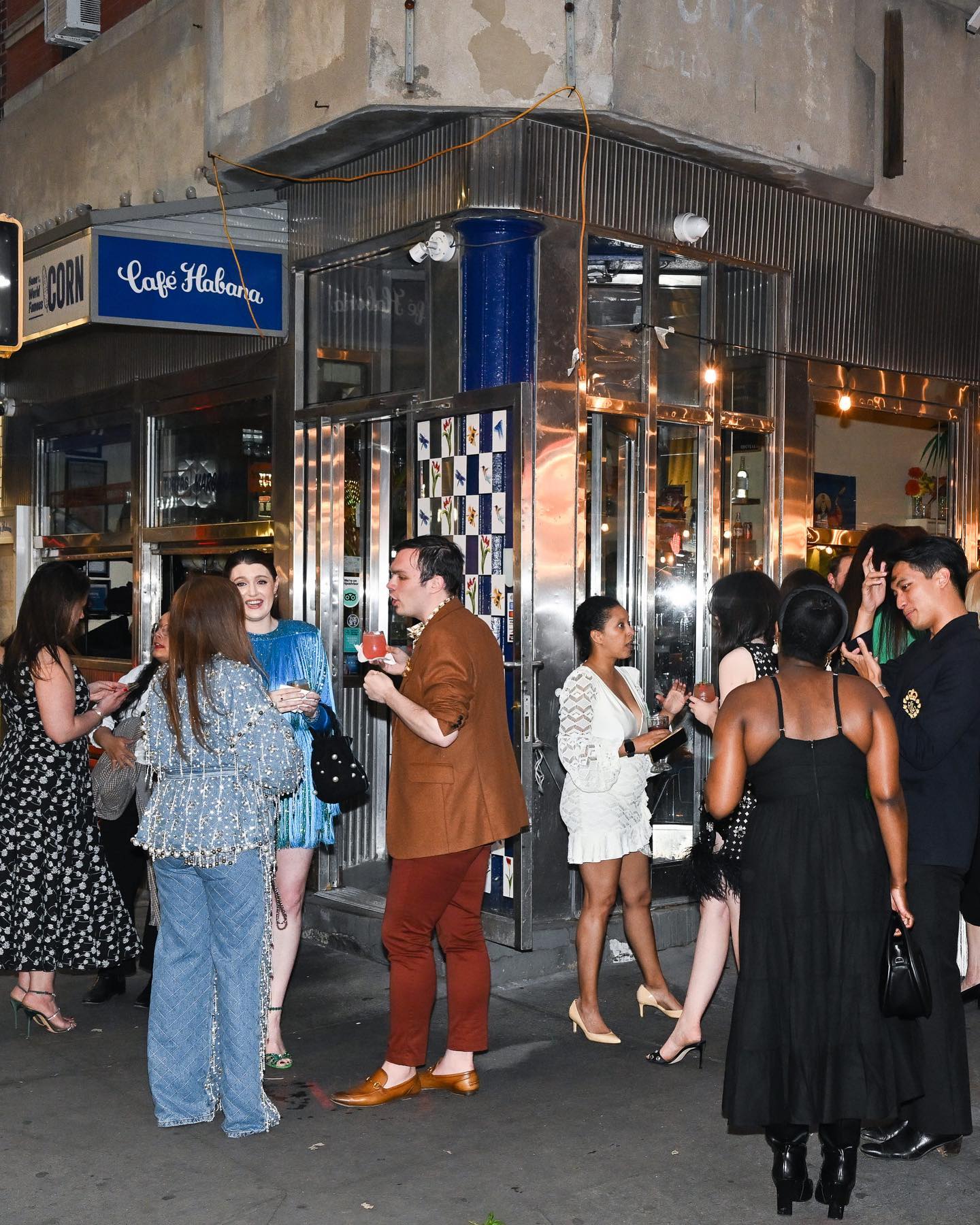 Guests with cocktails outside Café Habana on the Nolita corner