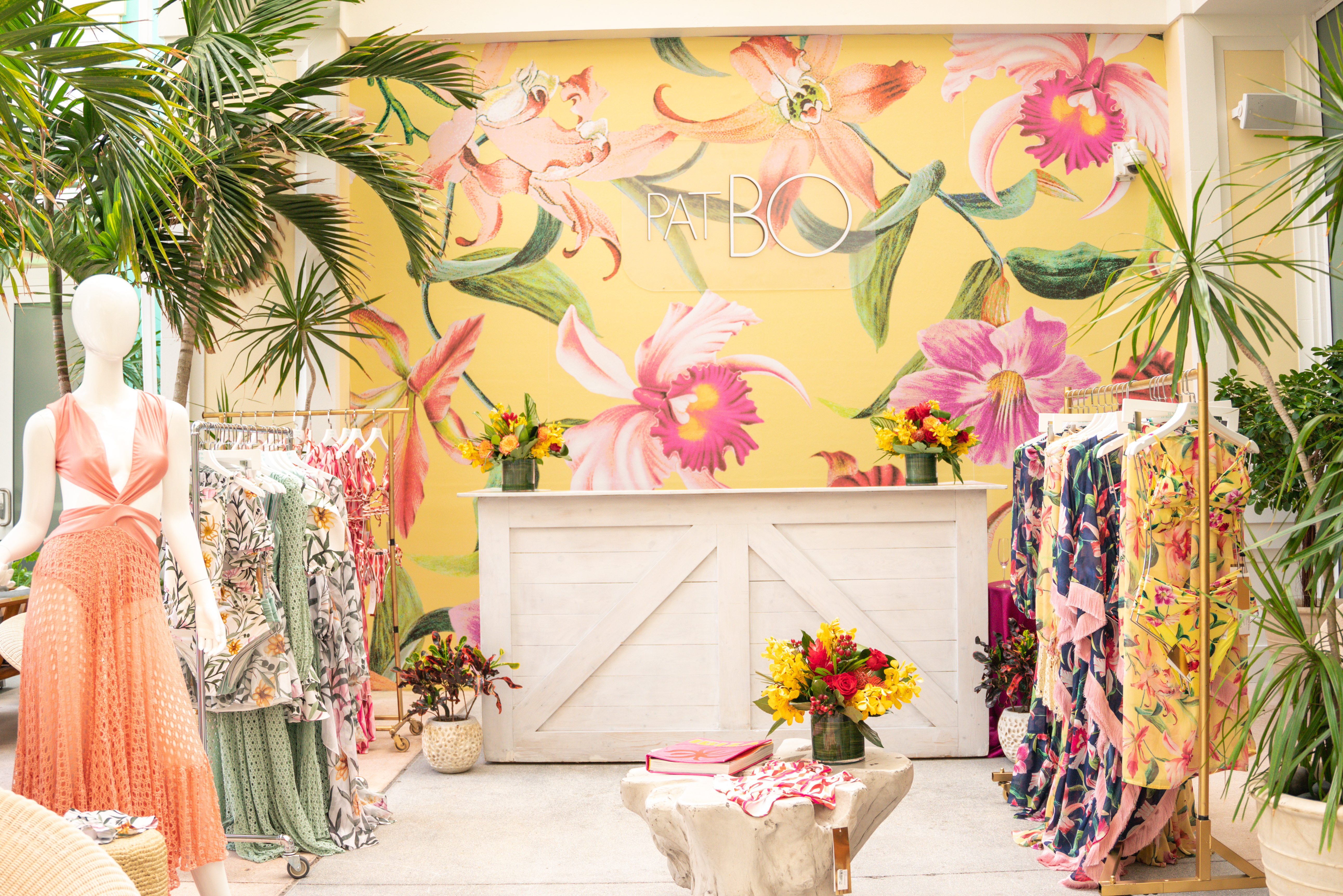 The PatBO pop-up shop interior with floral mural and rack of prints