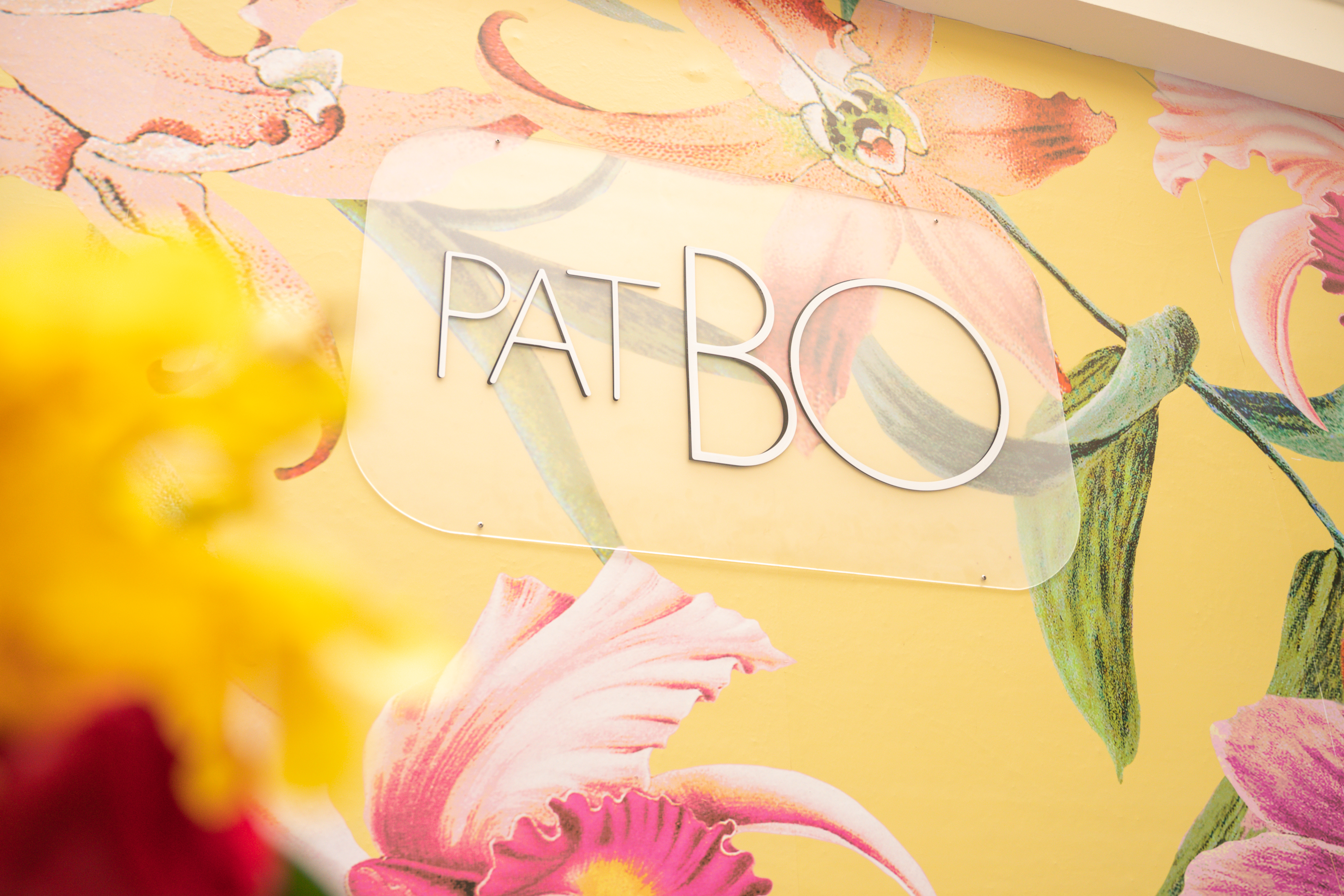 PatBO signage against the floral mural