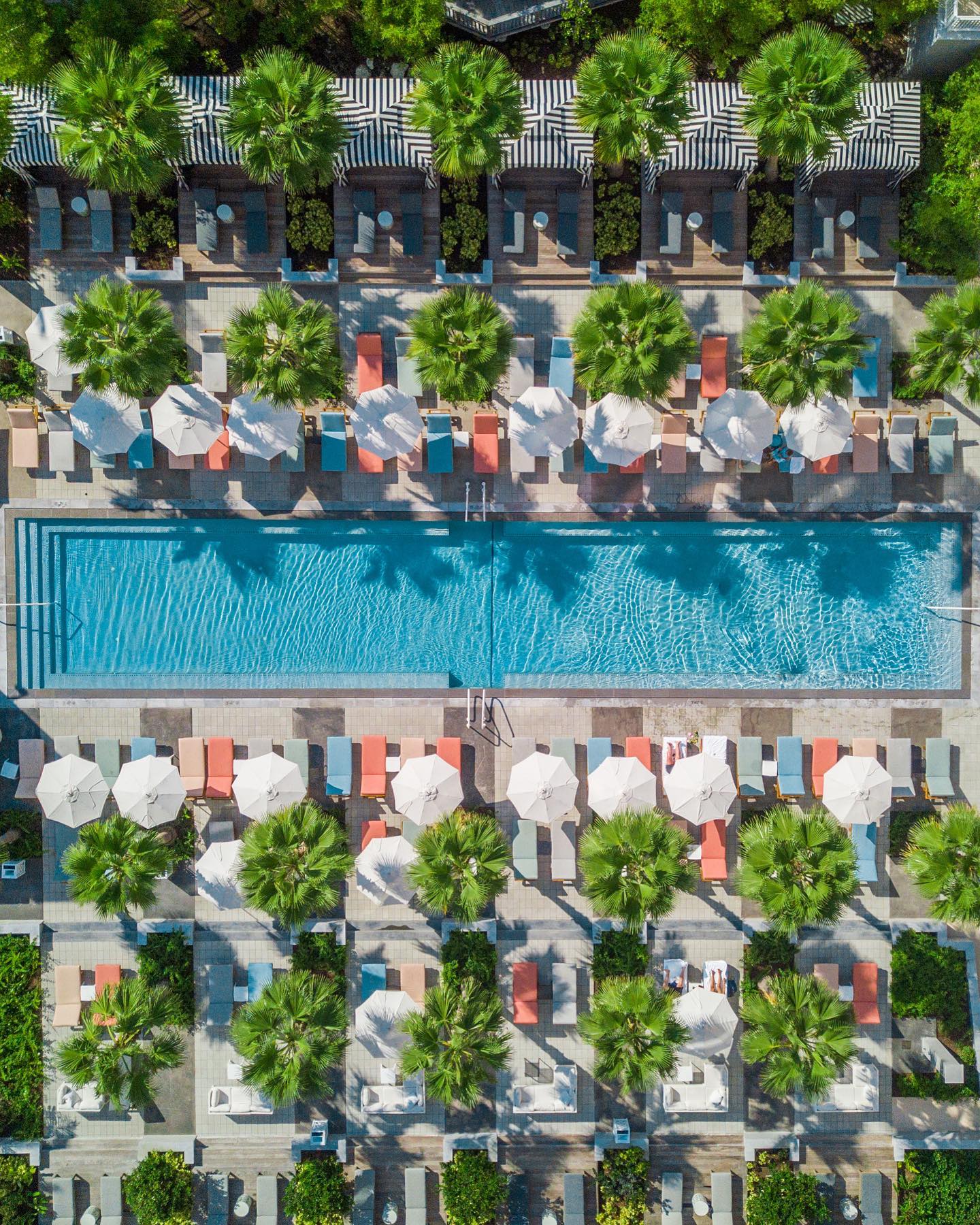 Aerial view of the SLS Baha Mar pool lined with palms and umbrellas