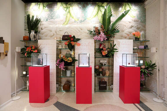 The launch installation with red pedestals and florals